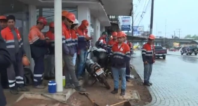 Obreros del metrobús ven la lluvia caer