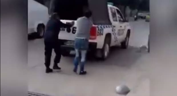 Preso esposado ayuda a empujar móvil policial