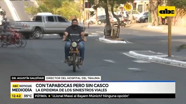 En moto, con tapabocas, pero sin casco