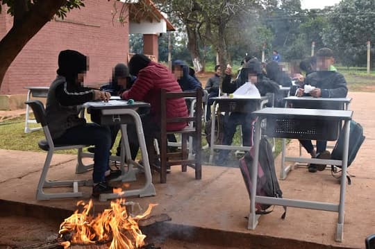 Sin aulas, a la intemperie y con fogatas: así estudian, sentados en pupitres chinos